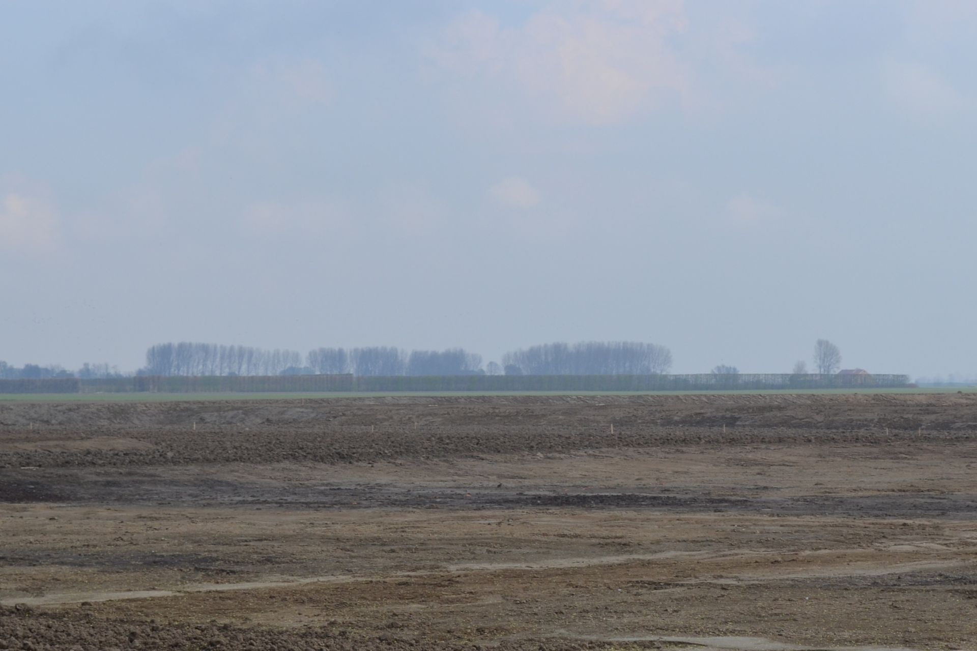 Lange donkere sporen in het afgegraven natuurgebied, zichtbaar in 2012.