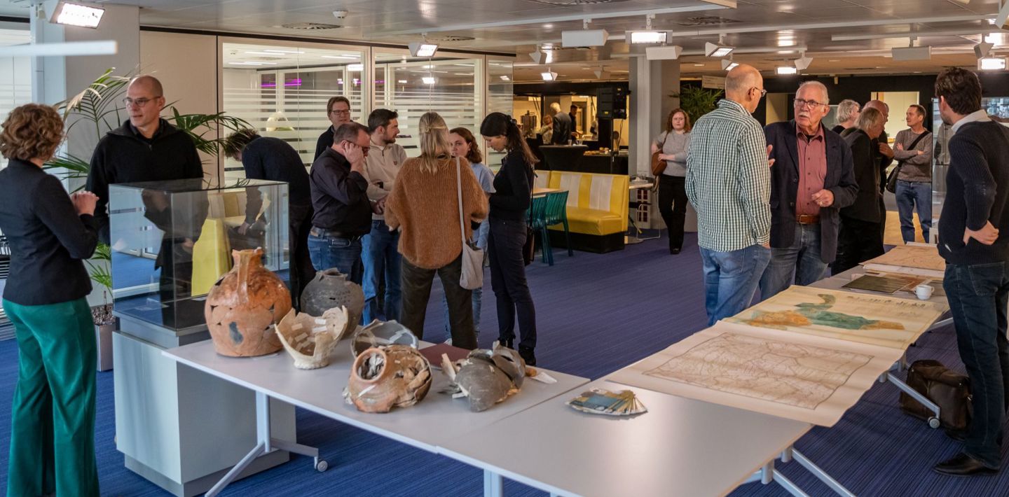Deelnemers van de jaarlijkse Zeeuwse Archeologiedag ontmoeten elkaar en bekijken vondsten op de interactieve markt.
