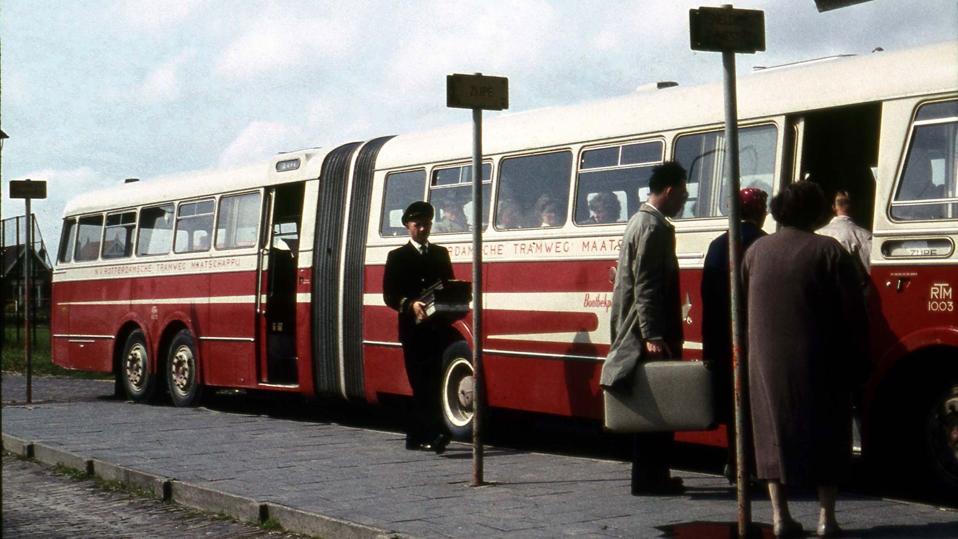 Reizigers stappen in een oude bus van de Rotterdamsche Tram Maatschappij.