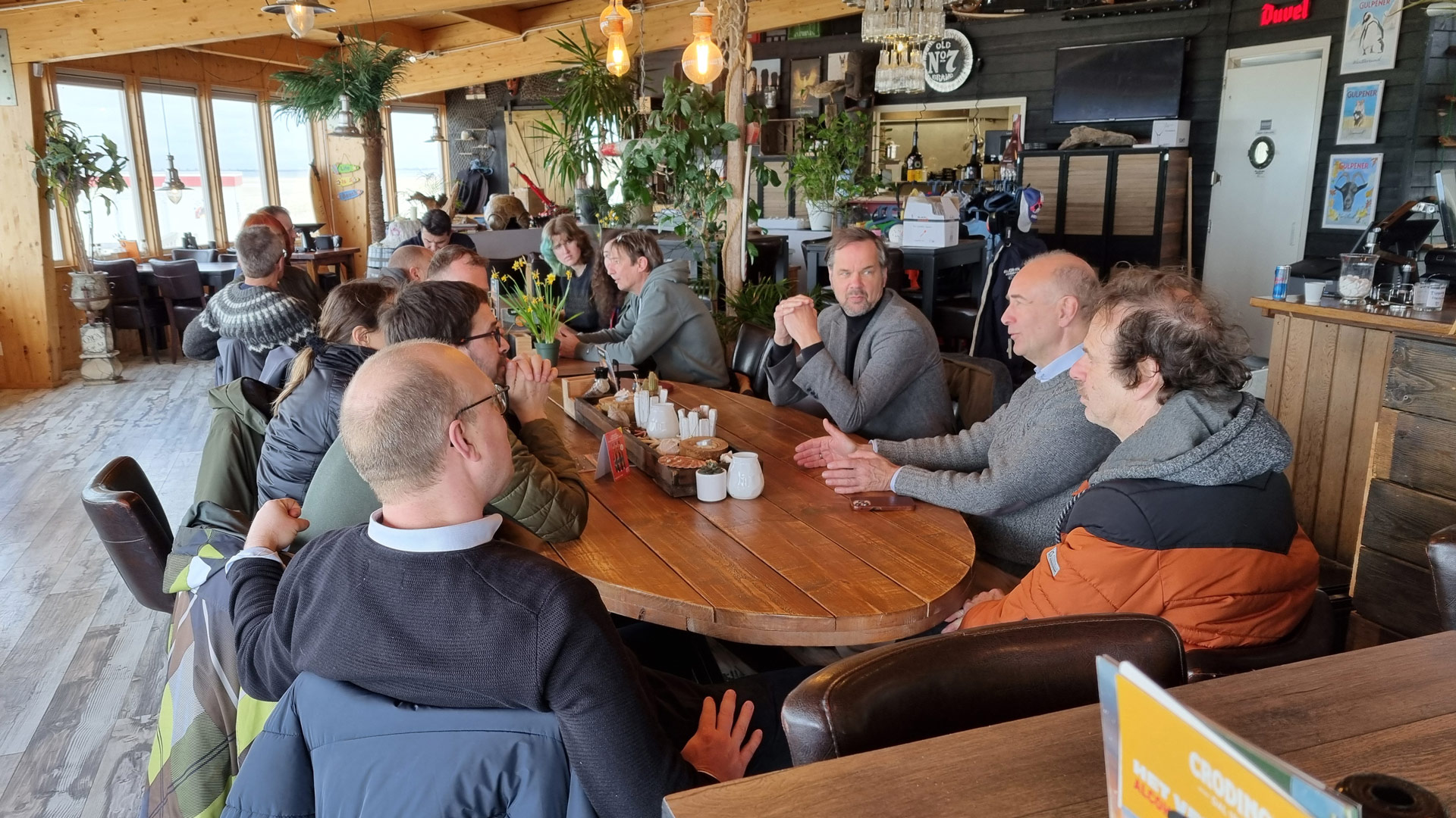 Gezamenlijk napraten in strandpaviljoen Aloha Beach na afloop van de opening.