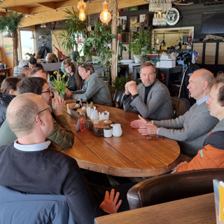 Gezamenlijk napraten in strandpaviljoen Aloha Beach na afloop van de opening.