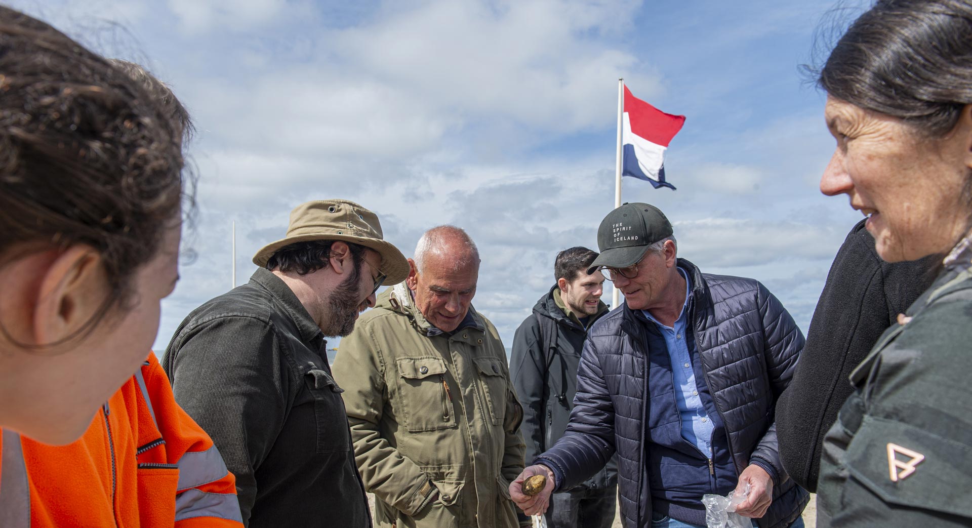 Strandzoekers tonen een strandvondst aan een archeoloog.