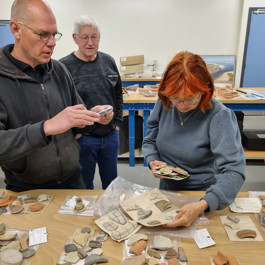 Onderzoekers bestuderen strandvondsten van het project Beach Archaeology in het archeologisch depot.